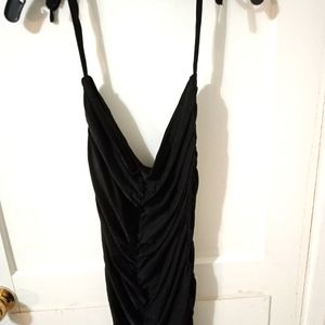 Black draped evening cocktail dress .